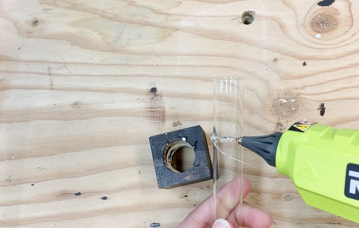 Adding a line of hot glue to attach test tubes