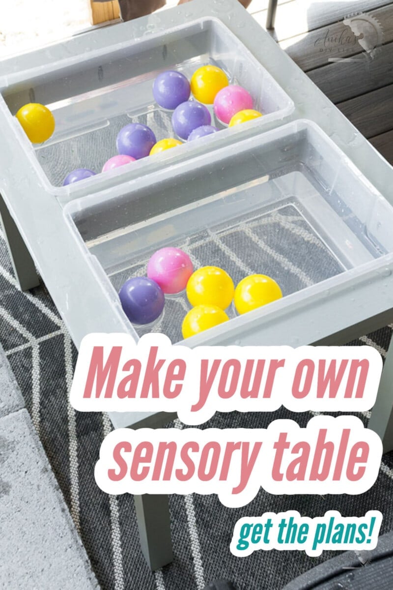 A wood water table with water and plastic balls in bins