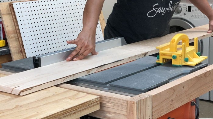 Running a board at 45 degrees through the table saw to make a miter edge on the DIY dining table