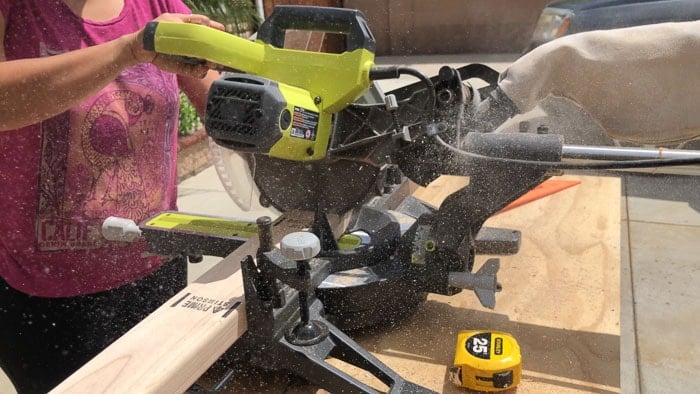Cutting 2x4 boards on a miter saw to build legs for the DIY Trestle dining table