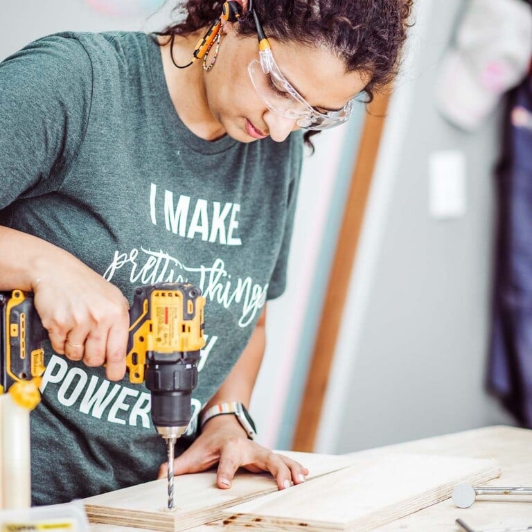 Woman using drill on wood