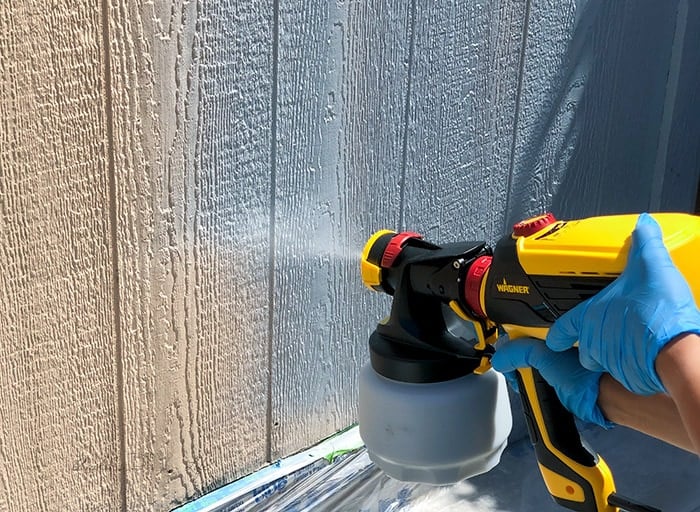 Spraying grey primer using Wagner's FLEXiO 3000. on to peach shed walls.