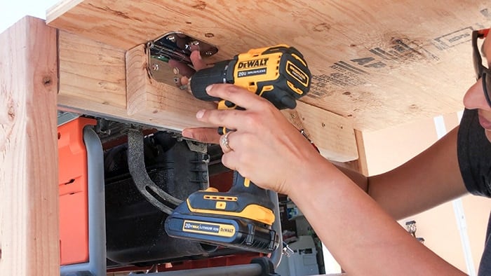 Attaching folding outfeed table to table saw stand using hinges