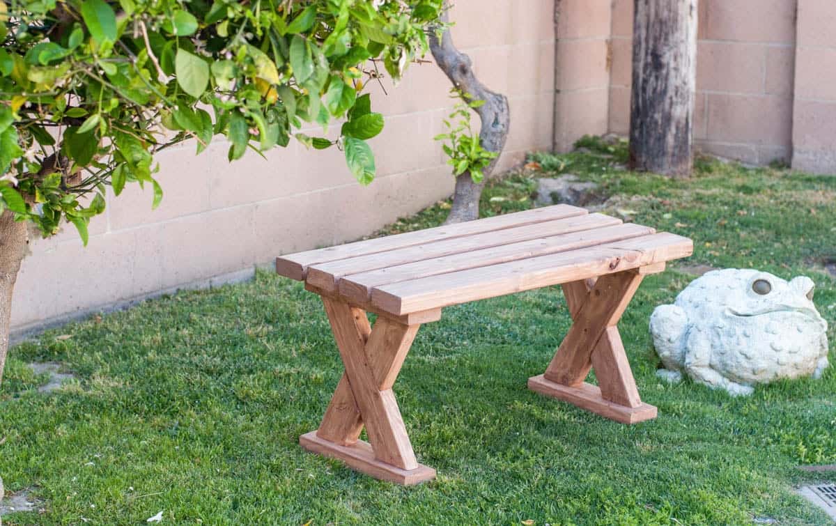 DIY 2x4 x-leg bench outdoors on the grass.