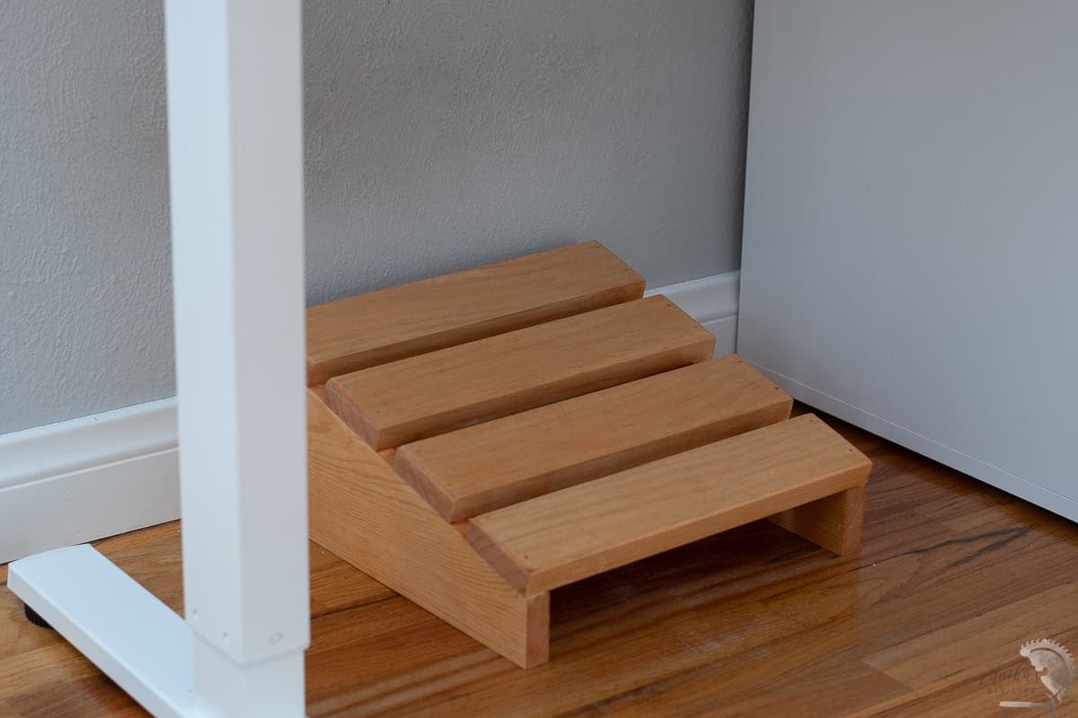 DIY custom wooden foot rest in brown under a desk