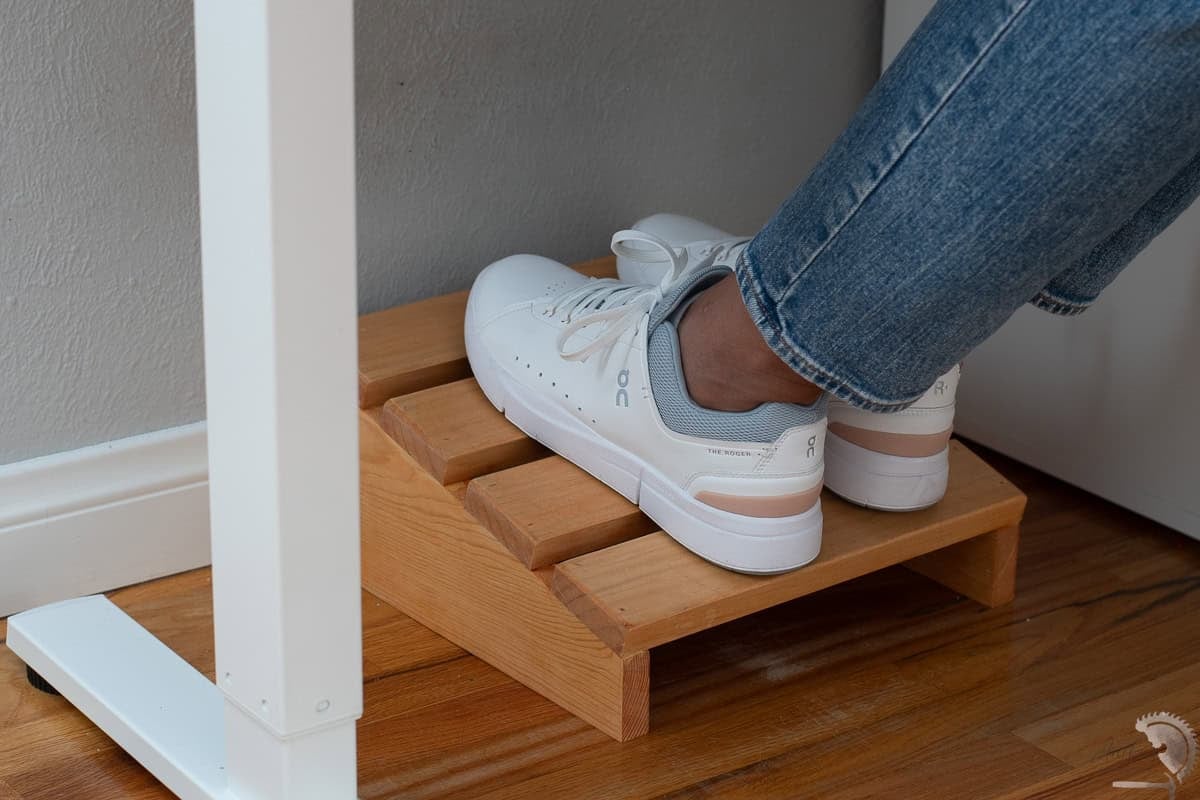 DIY wooden foot rest under table with feet resting on it
