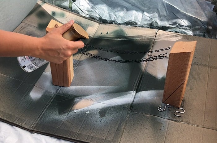 spray painting a set of chains with satin bronze