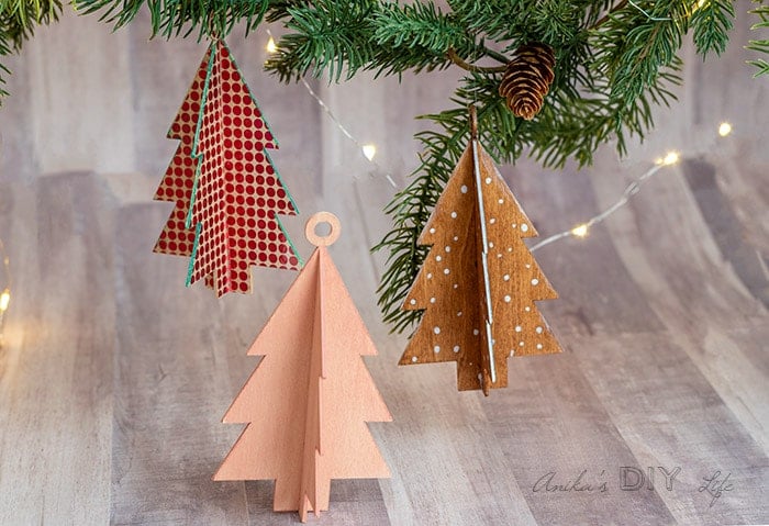DIY Christmas tree shaped wooden ornaments hanging from branch