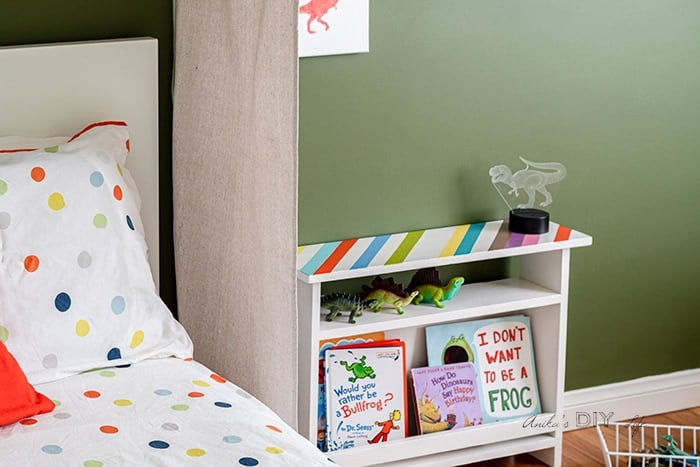 Kids bed and bookshelf in a dinosaur themed room