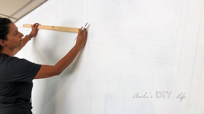 Woman Marking lines to paint a striped wall