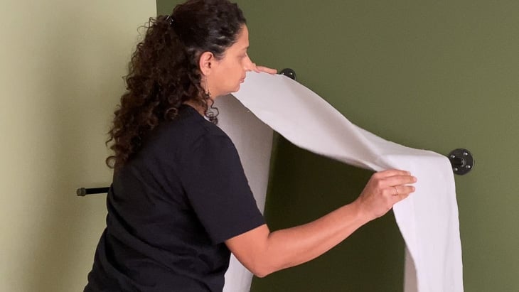 Draping the drop cloth on pipes to make a tent canopy
