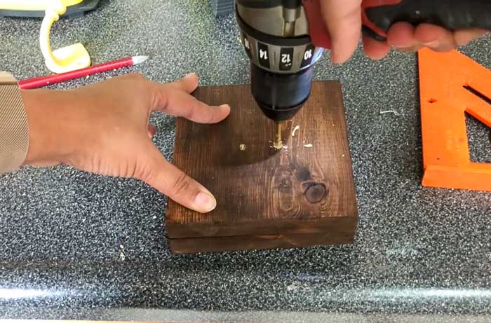 drilling pilot holes in wood boards to install hooks
