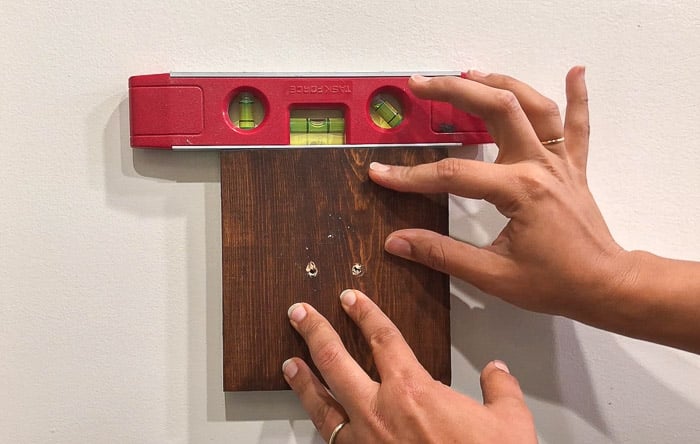 aligning and drilling holes in the wall using a level