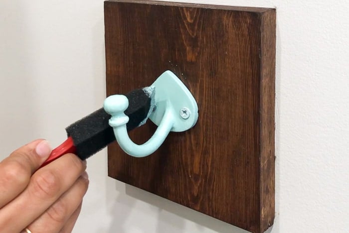touching up paint on the diy towel hooks in bathroom