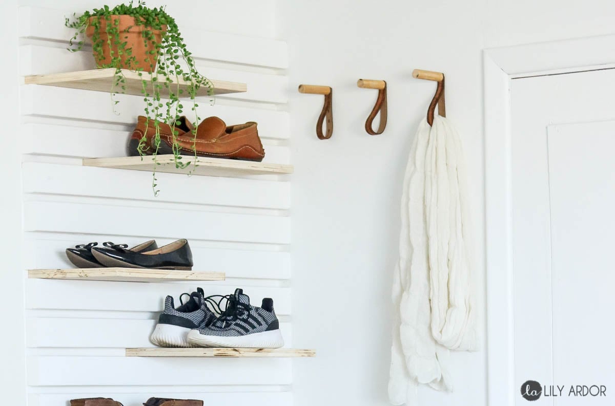 Shelves in planked wall for storing shoes in an entry