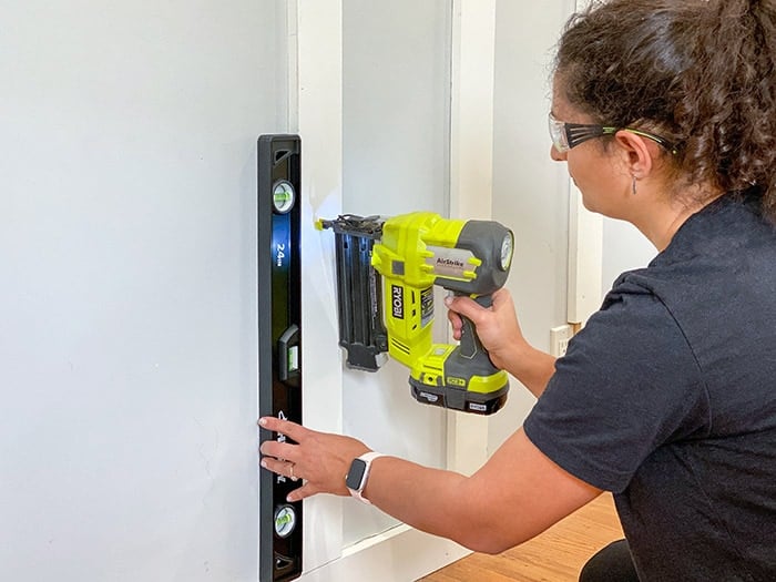 Woman attaching board and batten to wall