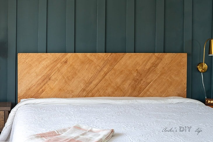 Plywood headboard against dark wall.