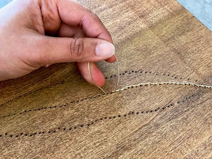 Making shaft of feather art using gold wire on wood