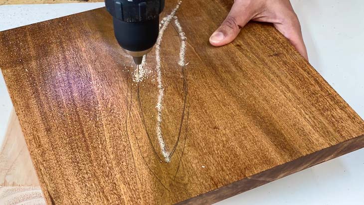 Drilling holes to make a wire and wood wall art