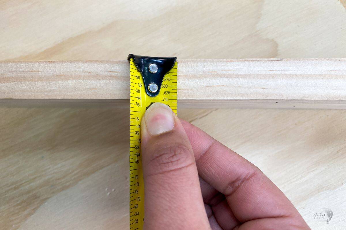 checking the thickness of a board using a measuring tape
