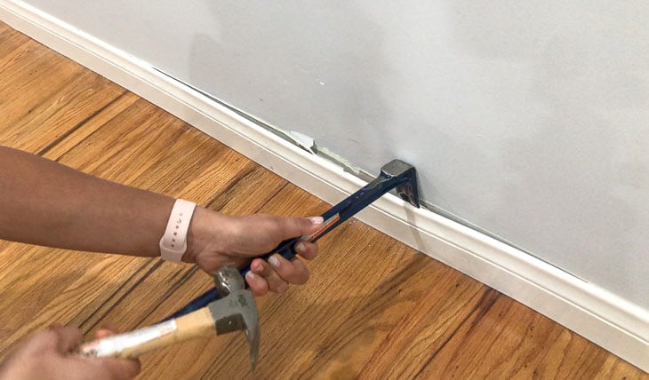 removing baseboards to install the dIY board and batten