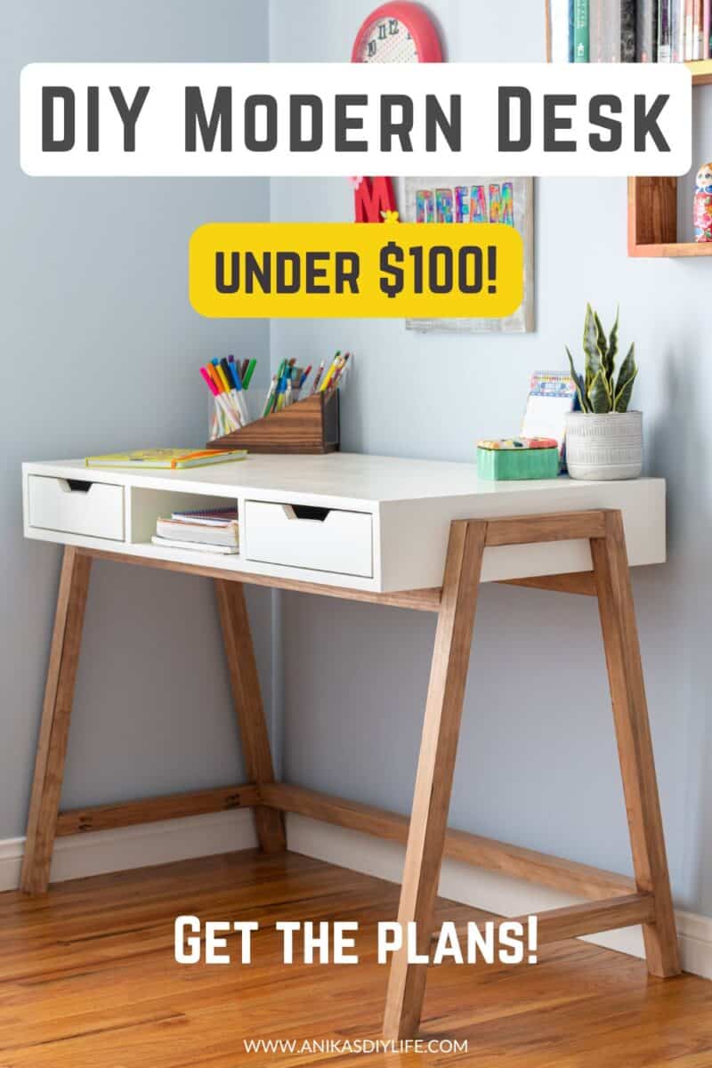 Modern DIY desk with white top and brown legs in room with wood floors. There is text overlay - diy desk, under $100 get the plans.