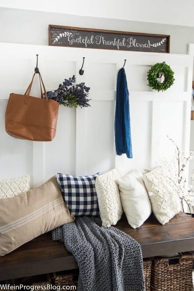 entryway with board and batten and hook with a bench in front