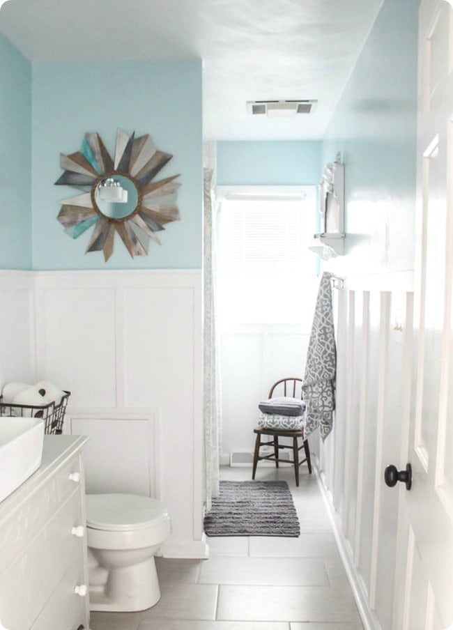 Half wall white board and batten in light blue bathroom