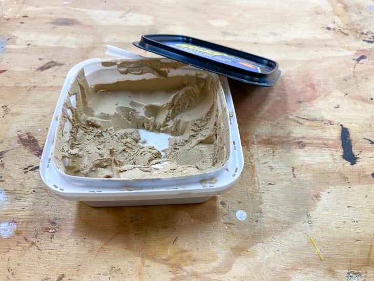 open box of wood filler on workbench