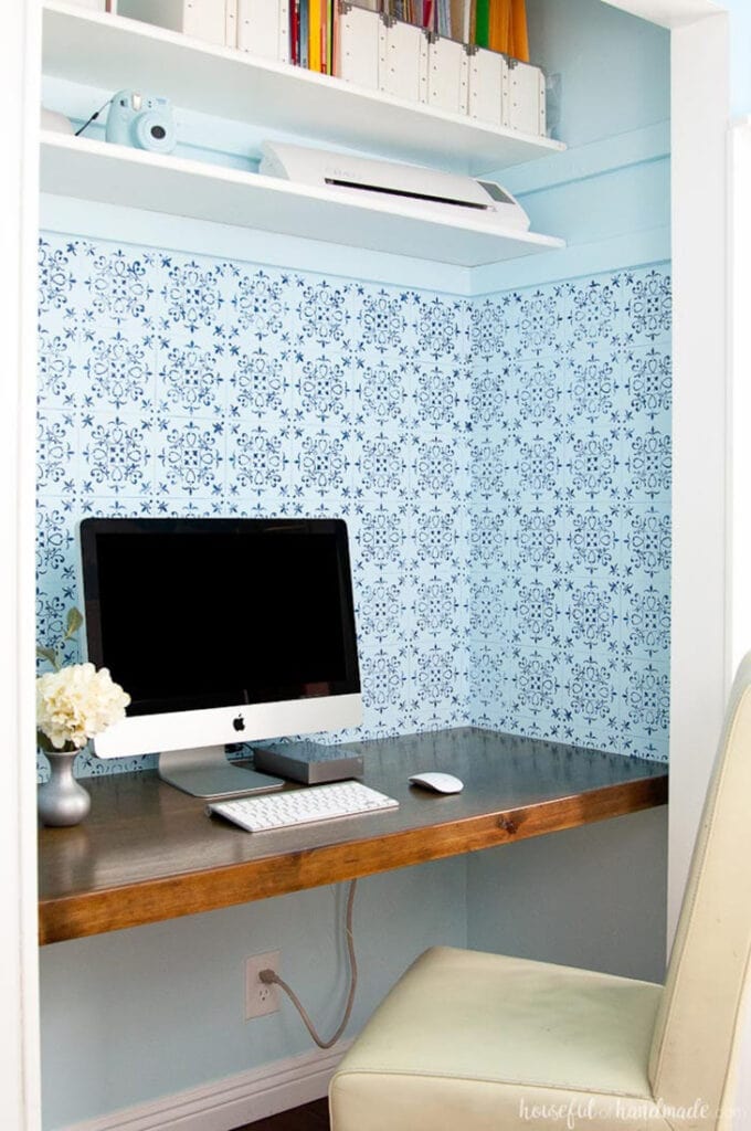 Floating desk in a closet with open shelving above