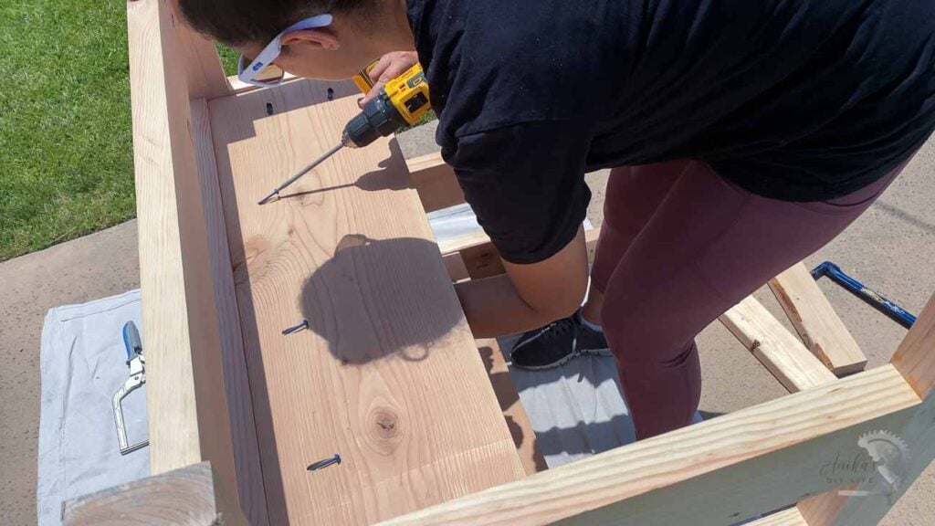 Woman attaching shelf using pocket hole screws