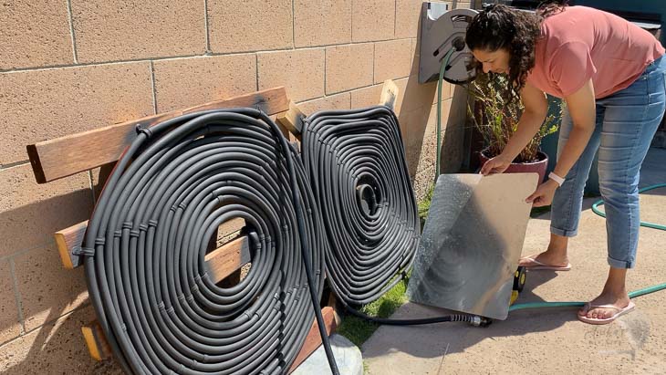 woman adding reflectors tp help solar pool heaters.
