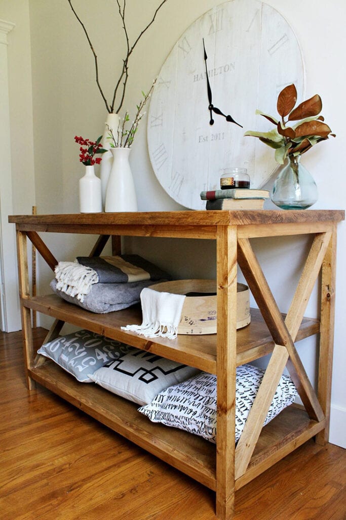stained wood console table with X details on the sides and two shelves