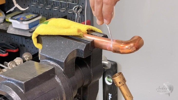 Woman soldering copper tubes together