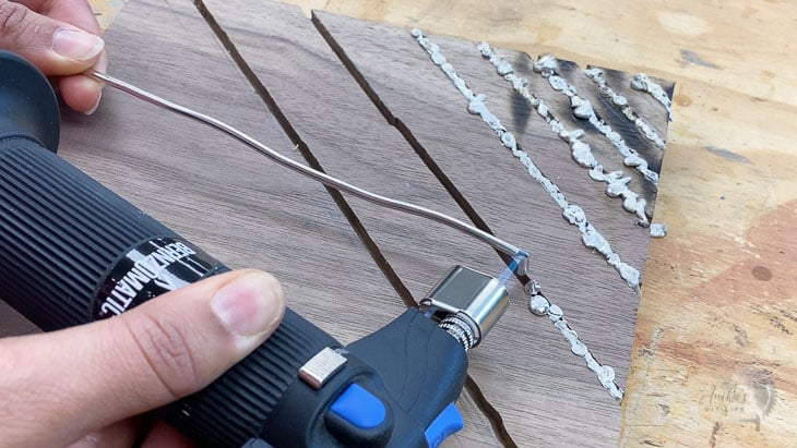 melting metal solder into grooves with a small torch