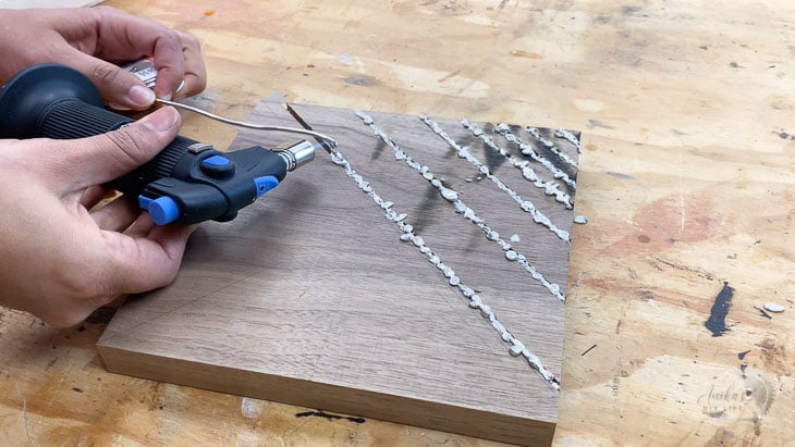 melting solder into grooves of a wood wall clock