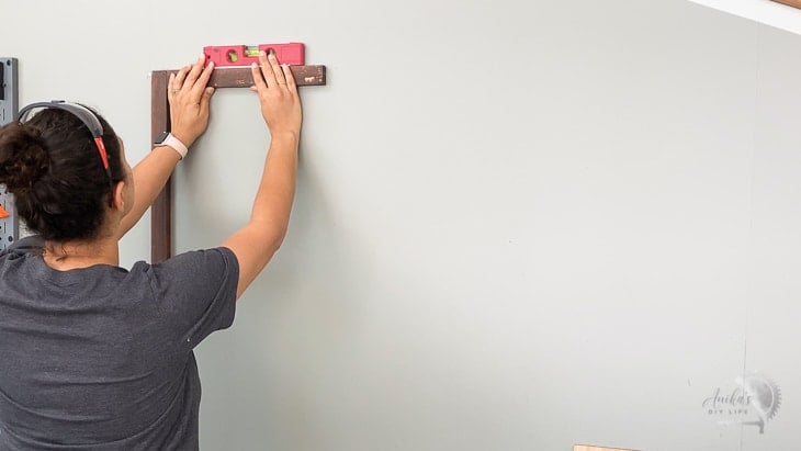 attaching boards to studs to mount the plywood pegboard