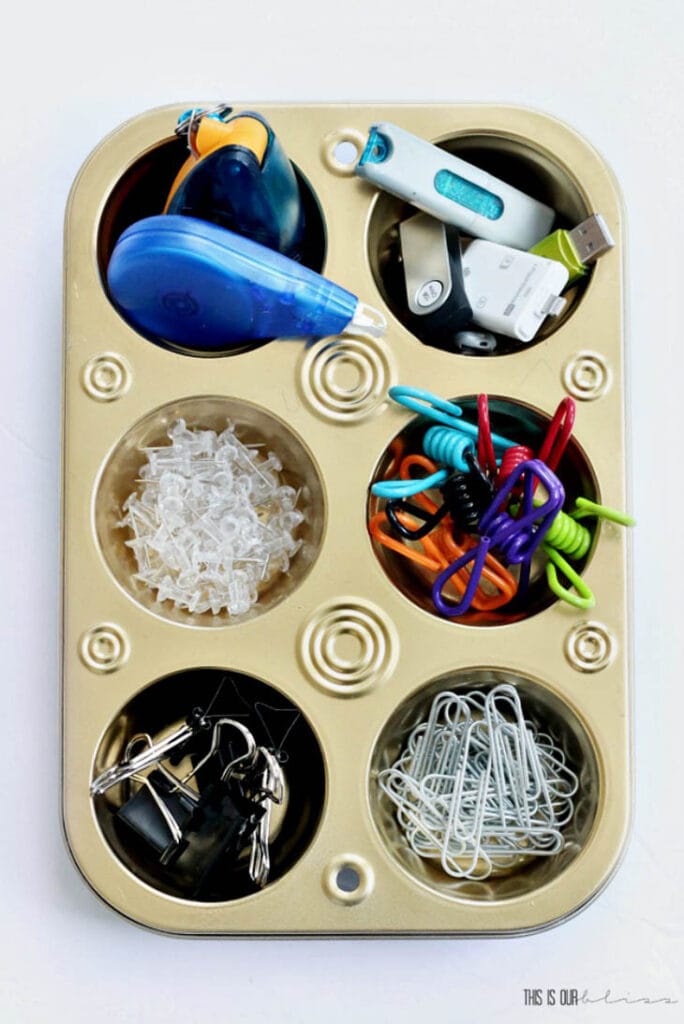 cupcake tin spray painted gold with office supplies in the sections