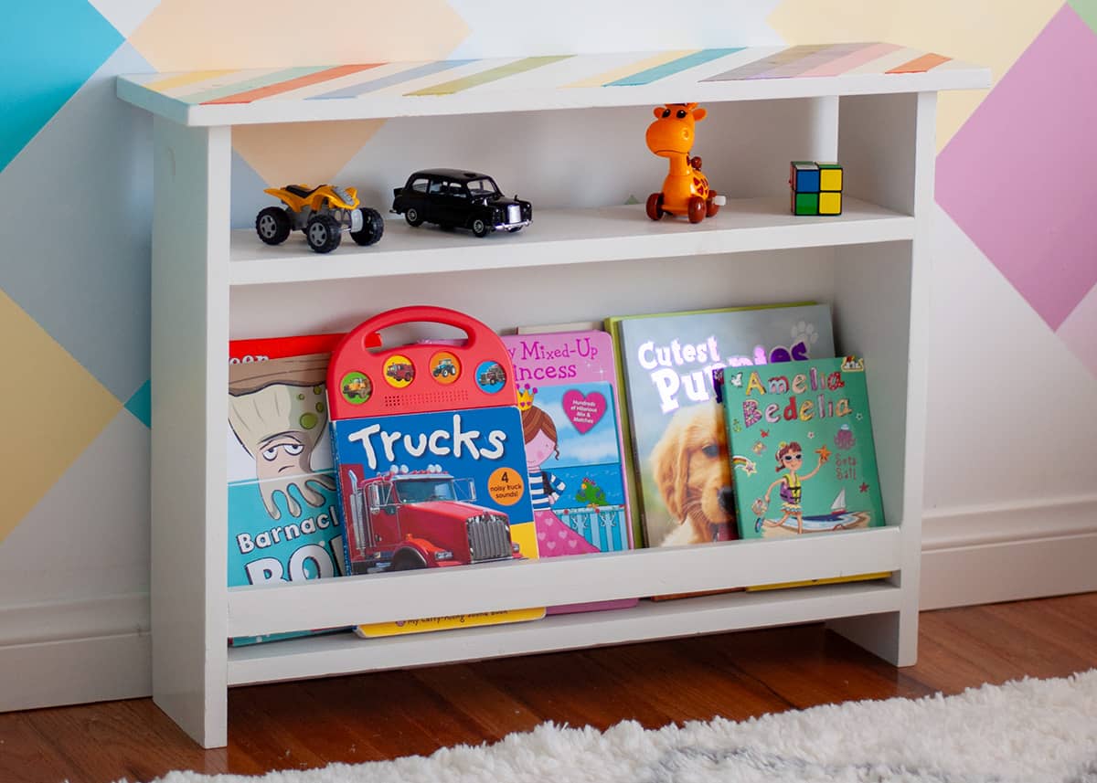 Small kids bedside table with toys and books in colorful room