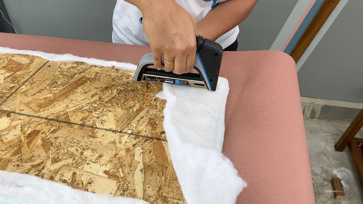 Woman attaching batting using staple gun