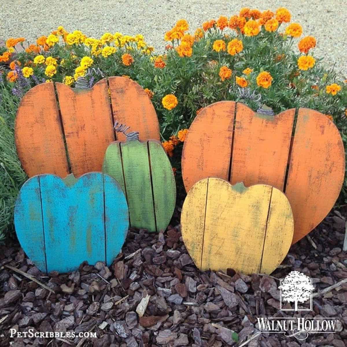 five pumpkins painted different colors made from pallet wood