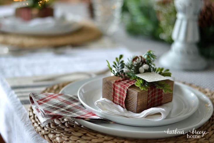 square scrap wood block with plaid ribbon and name card on a place setting