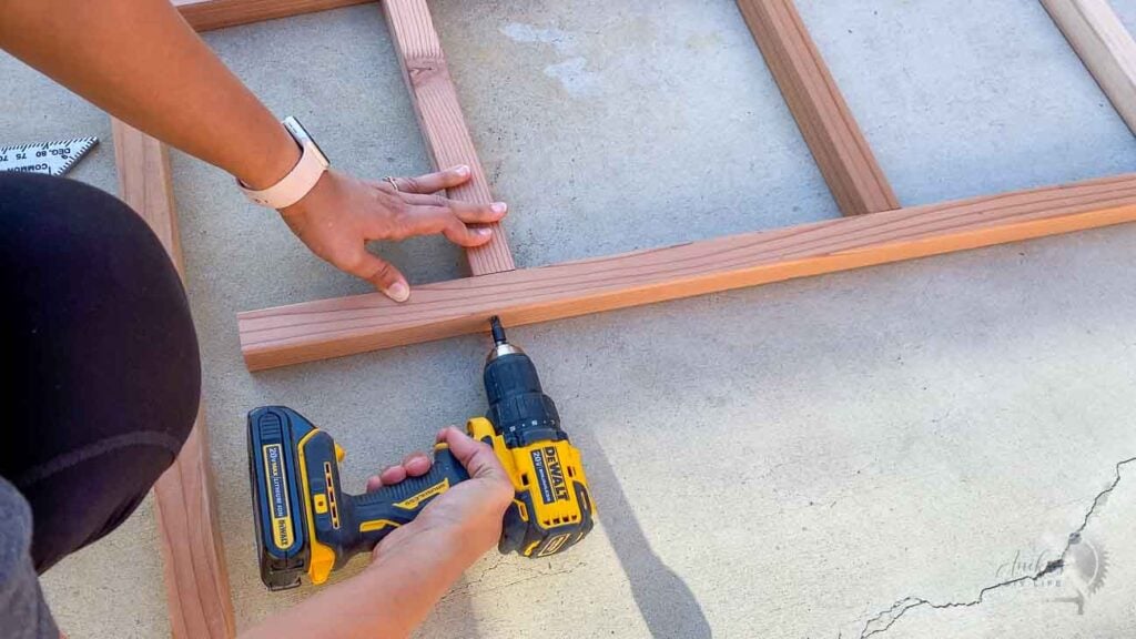 Woman attaching legs using wood screws.