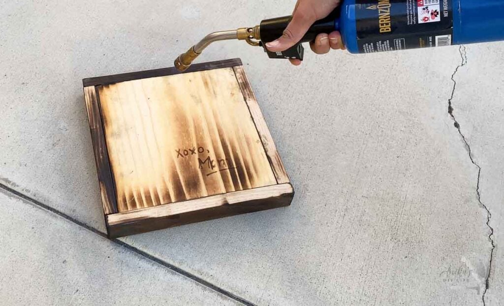 Using a blow torch to show message written with scorch marker.