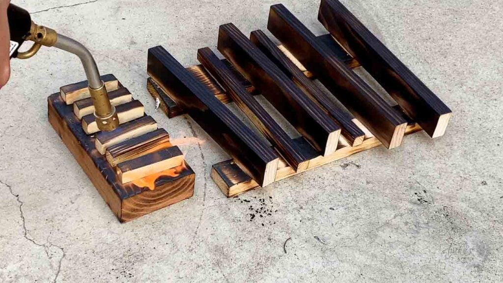 Close up of using a blowtorch on the wood to get the charred effect