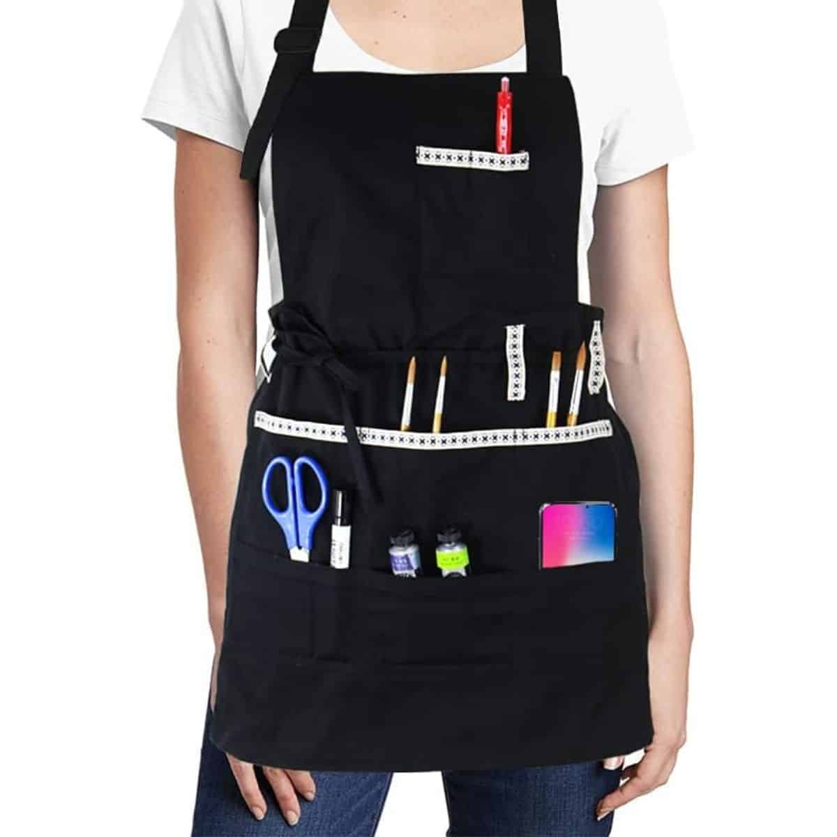 woman wearing black apron with crafting tools