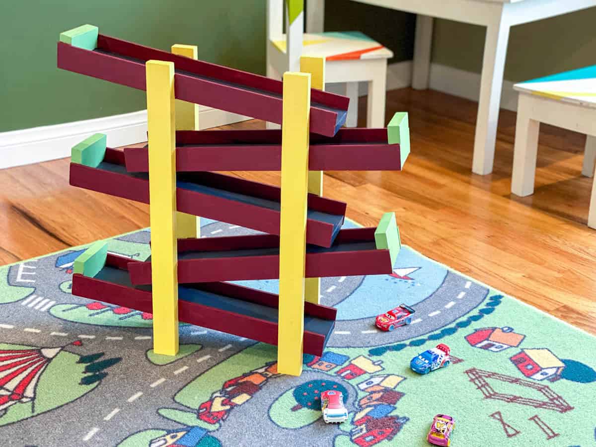 DIY toy car ramp with cars on traffic motif rug