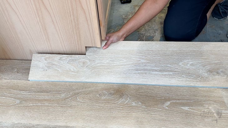 installing a cut out vinyl plank in a kitchen
