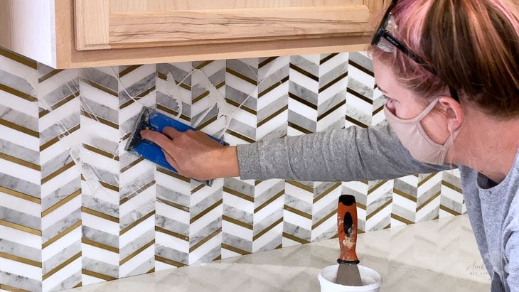 applying grout to the mosaic tile