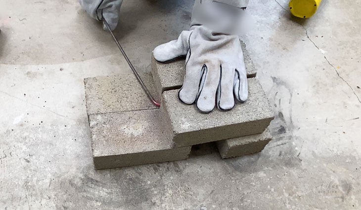 Bending steel rod around a cement brick